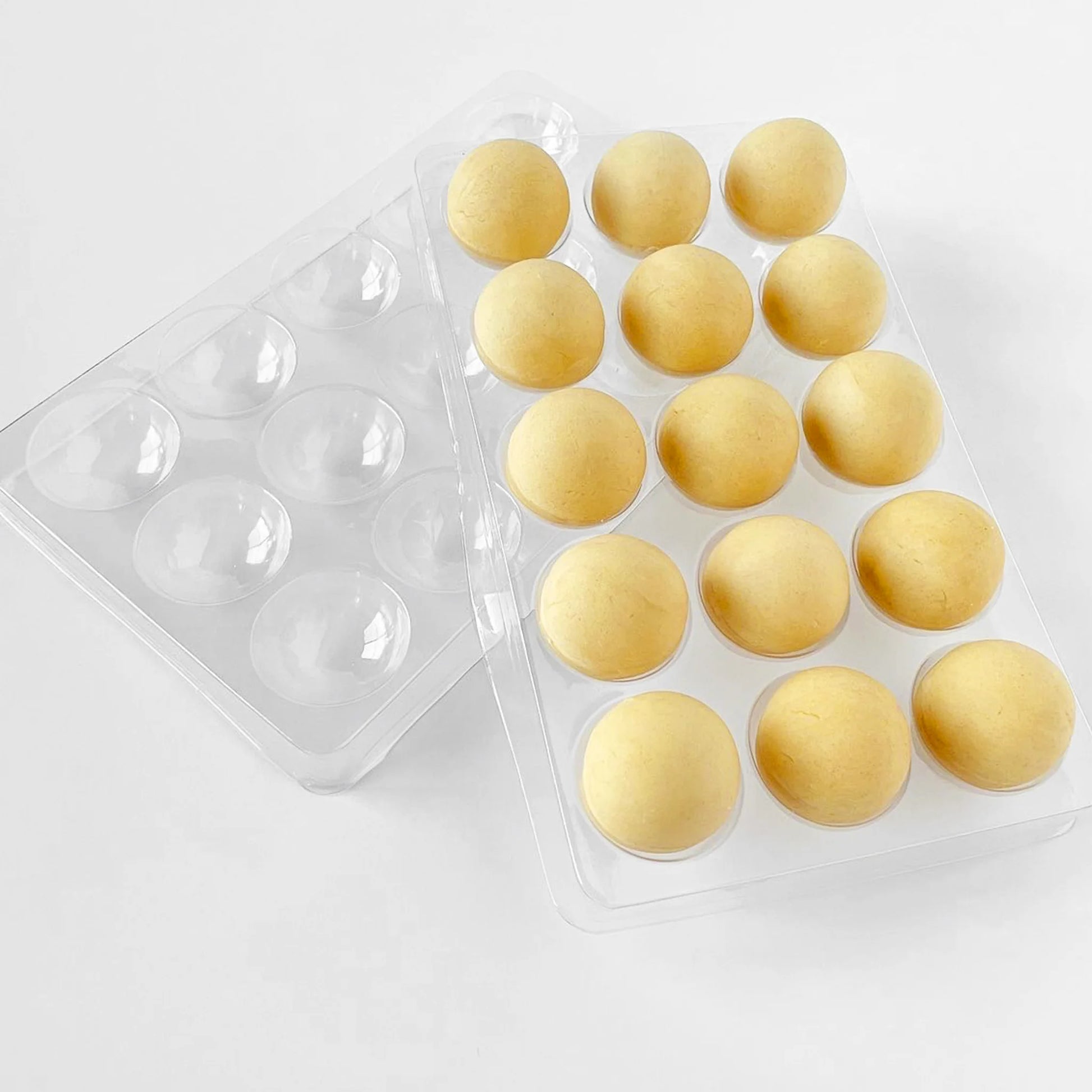 Clear plastic cake pop resting trays filled with round cake dough shapes, designed to hold and support cake pops while chilling or decorating.