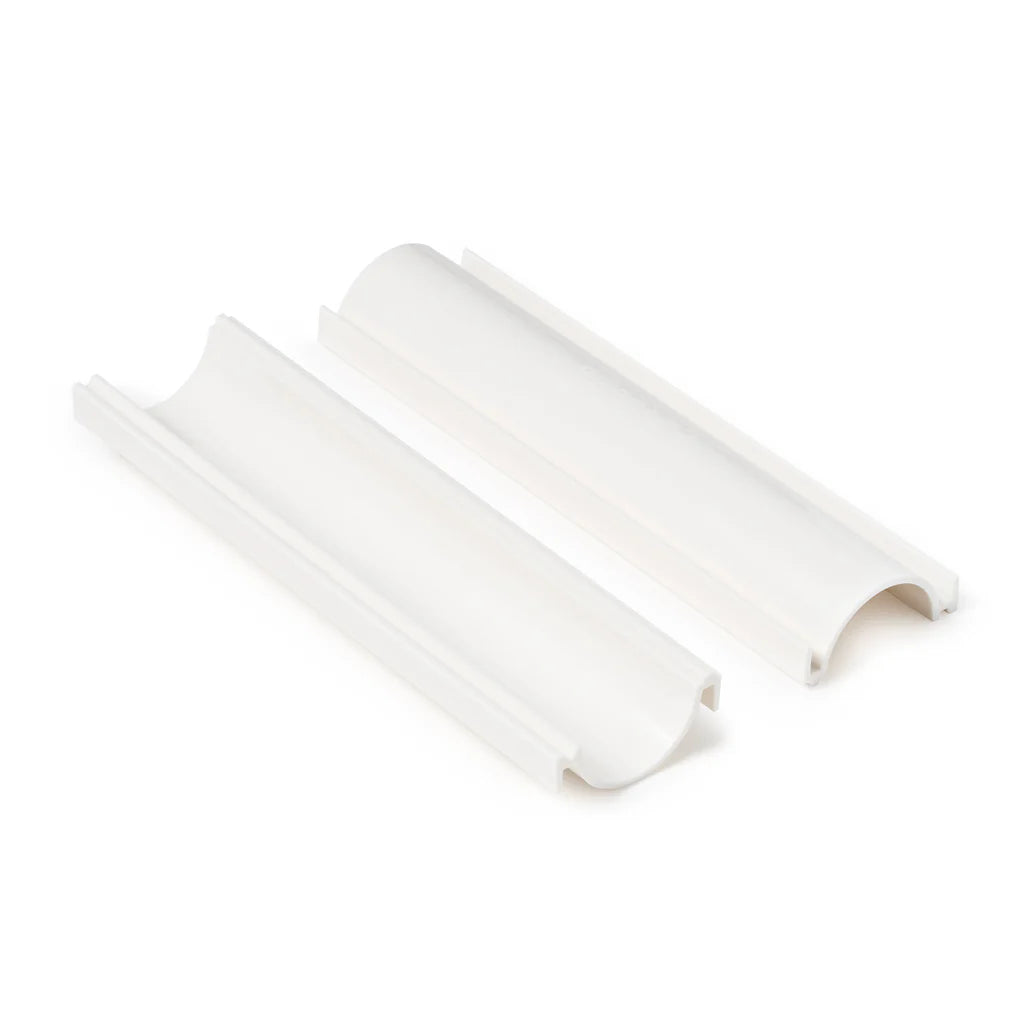 White cake pop roller shown separated into two matching curved channel pieces with raised rails and rounded ends on a white background.