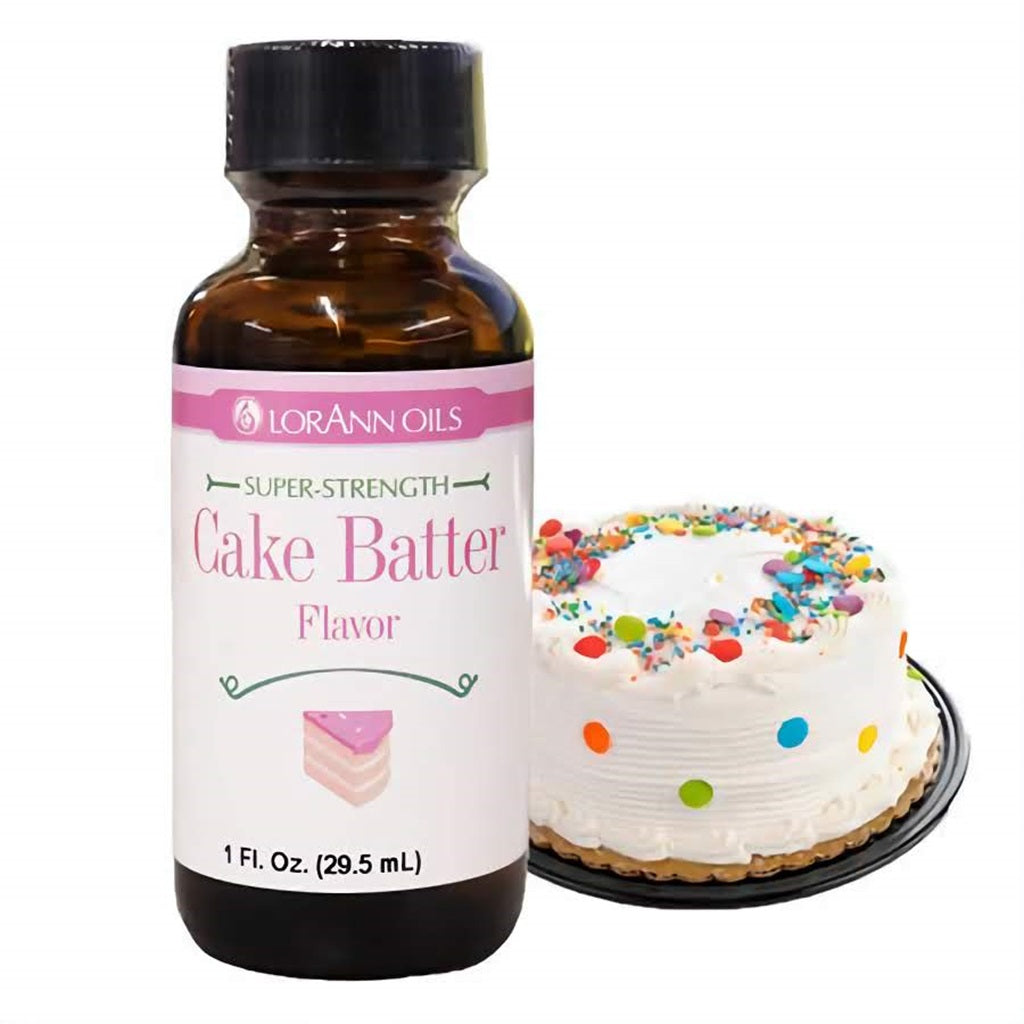 LorAnn Oils Super Strength Cake Batter Flavor in a 1 fl oz bottle, beside a festive decorated cake with sprinkles, suggestive of homemade batter taste.