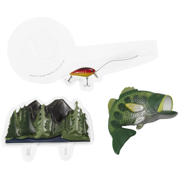 A three-piece cake decoration set featuring a fish figurine, a scenic forest background, and a fishing line with bait.