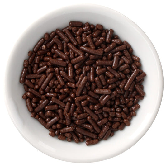White bowl filled with deep chocolate-brown Natural Dyed Made Simply™ rod-shaped sprinkles, shown from above on a clean white background.