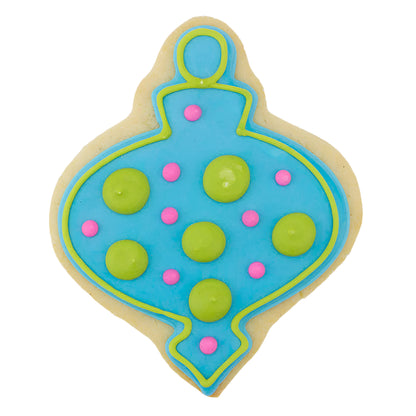 Decorated sugar cookie shaped like a finial Christmas ornament, with purple icing, intricate blue snowflake details, and a gold top.