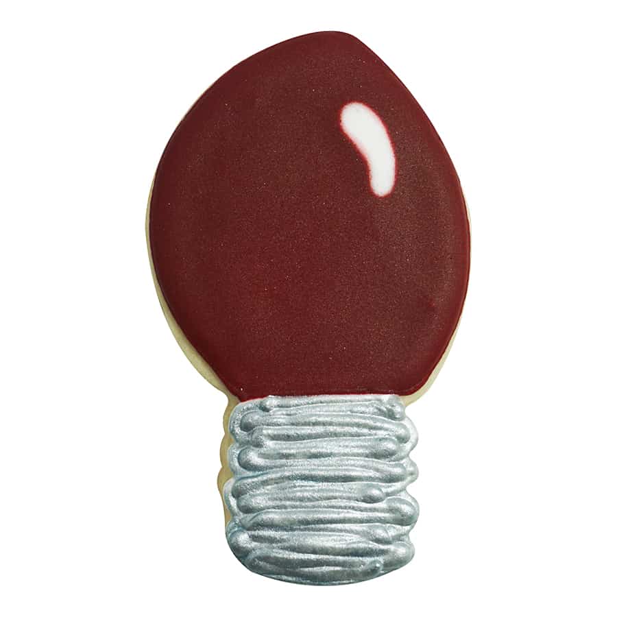 Decorated sugar cookie shaped like a holiday lightbulb with deep red icing and a metallic silver base.