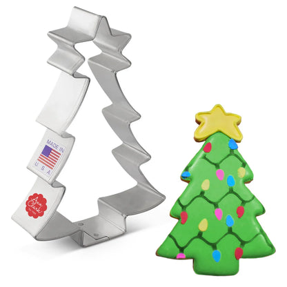 Side view of the tree cookie cutter next to a decorated cookie with green icing, colorful holiday lights, and a yellow star topper.