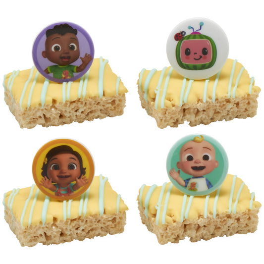 Four frosted rice cereal treats with pale yellow icing drizzle, each topped with a Moonbug character ring in bright colored circles, shown on a white background.