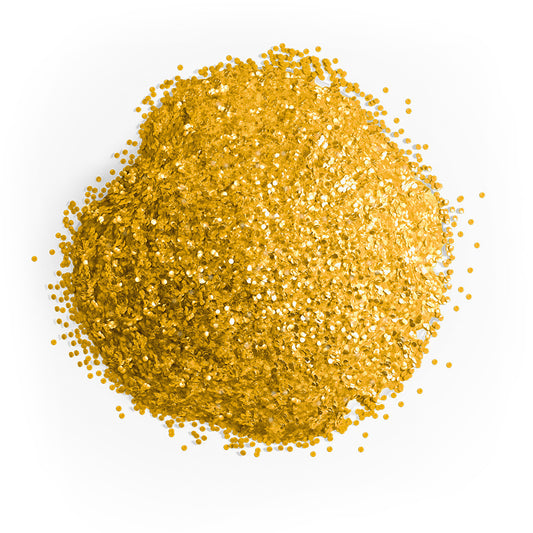 Close-up mound of Colour Mill gold edible glitter showing densely packed reflective golden particles scattered across a white background.