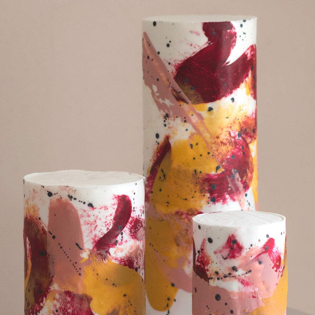 Tall buttercream cakes painted with abstract designs using Colour Mill Burgundy and complementary warm tones, including caramel and blush