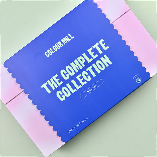 Colour Mill “The Complete Collection” gift box in blue and pink with scalloped edging; labeled Oil Blend, 20 ml x 60 colors; premium food coloring set packaging.