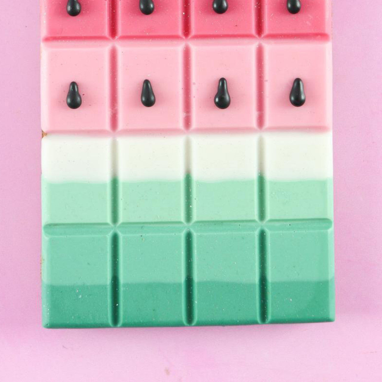 Watermelon-inspired chocolate bar featuring pink, white, and emerald green layers with chocolate “seeds.”