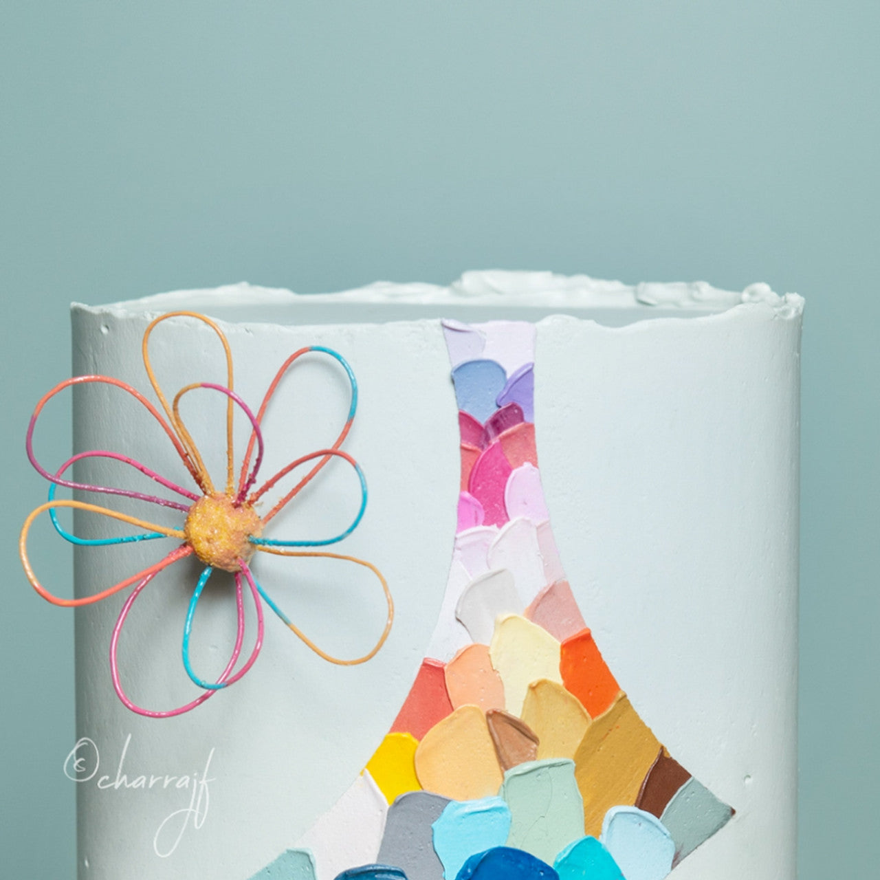 Cake decorated with Colour Mill Eucalyptus-toned buttercream and colorful palette knife painted details.