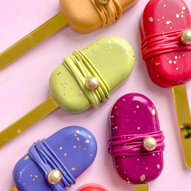 Colorful popsicles decorated with Colour Mill Kiwi and other bold pigments, featuring gold splatter and decorative accents.