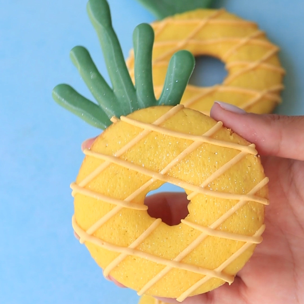 Pineapple-shaped cookies decorated with Colour Mill Lemon yellow and green frosting.