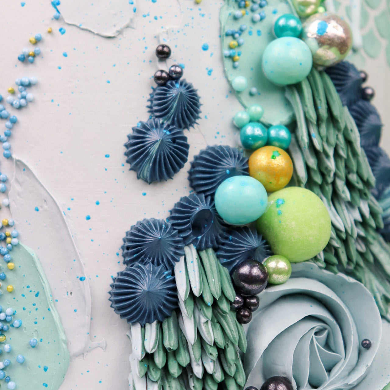 Decorated cake with shaggy piped textures in midnight blue, mint green, and turquoise using Colour Mill Midnight