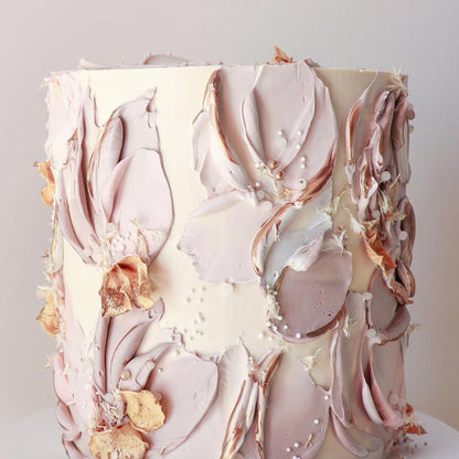 Cake decorated with soft taupe buttercream florals and dried accents
