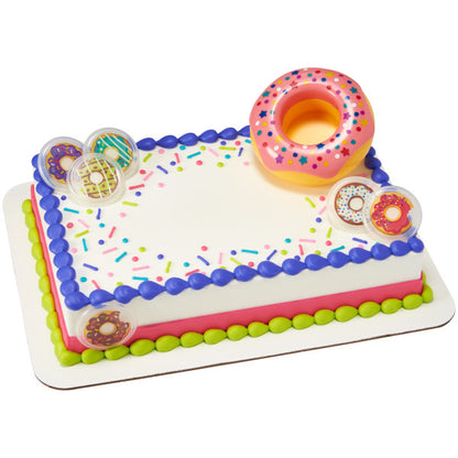 A rectangular cake with bright frosting and sprinkle decorations, featuring the large donut topper and mini donut layons.