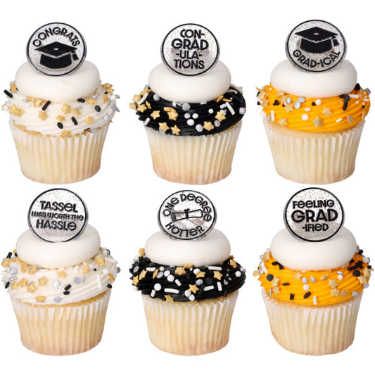 Six cupcakes with white, black, and orange frosting swirls topped with white icing discs, graduation sprinkle mixes, and confetti grad cupcake rings.