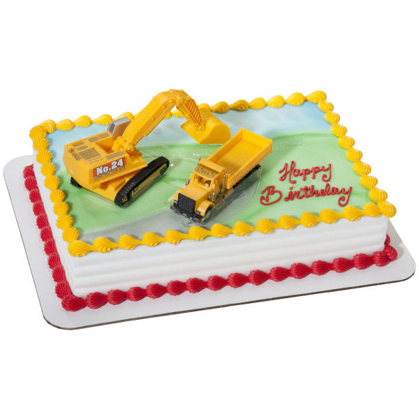 A rectangular cake with a construction-themed design, featuring the excavator and dump truck toppers.