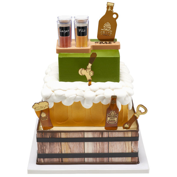 A square, beer-inspired cake topped with a foam-like frosting and brewery-themed decorations.