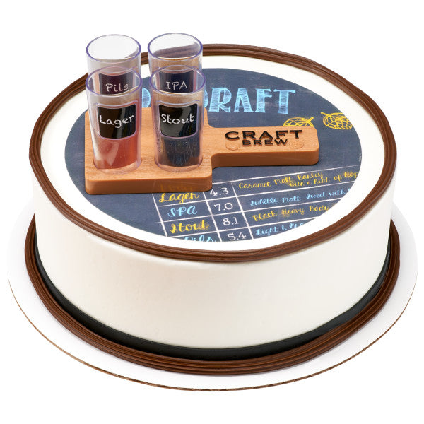 A round cake decorated with a beer menu design, featuring the beer flight paddle and mini cups as toppers.