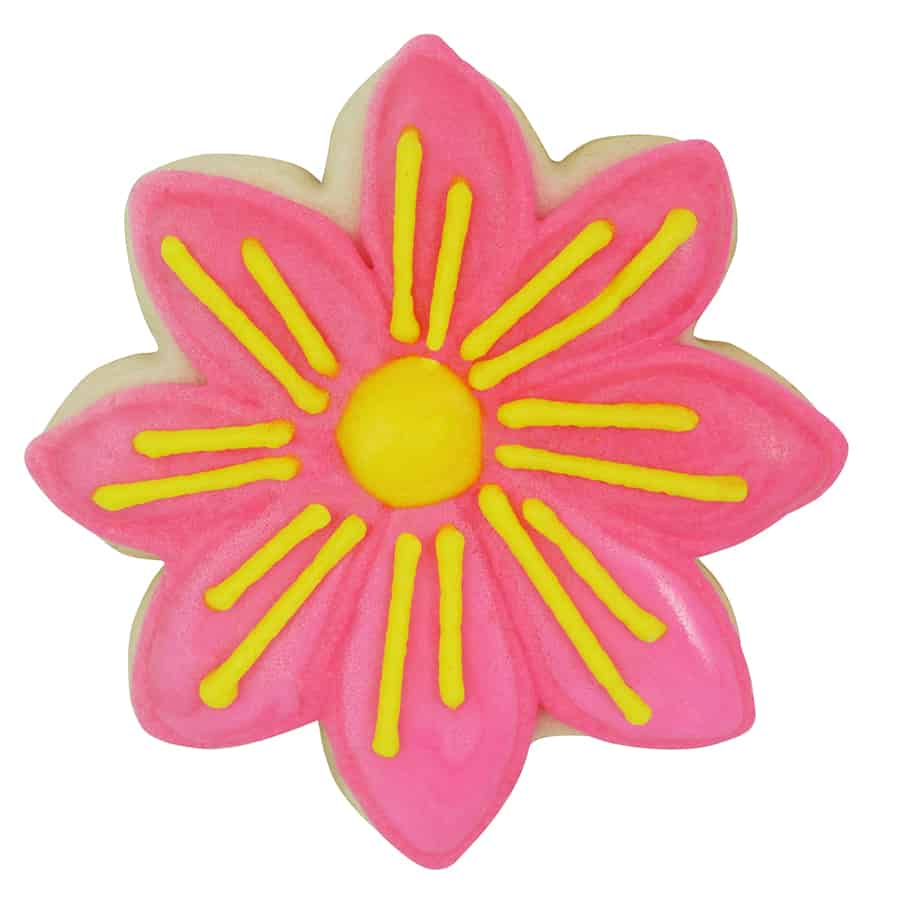 Pink daisy-shaped cookie with bright yellow icing details and a yellow center, showcasing a floral design.