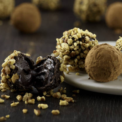 Chocolate truffles with nuts on a dark surface