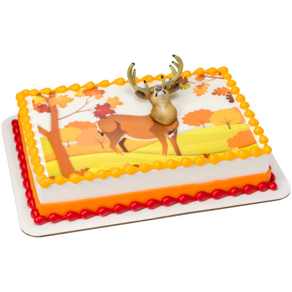 A rectangular cake with an autumn-themed background and the deer head topper as the centerpiece.