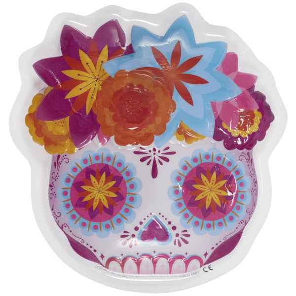 Close-up of Día de los Muertos skull cake topper with colorful floral accents and intricate details.