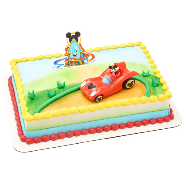 A vibrant cake with a racetrack design, featuring the Mickey Mouse car topper and Funhouse backdrop.