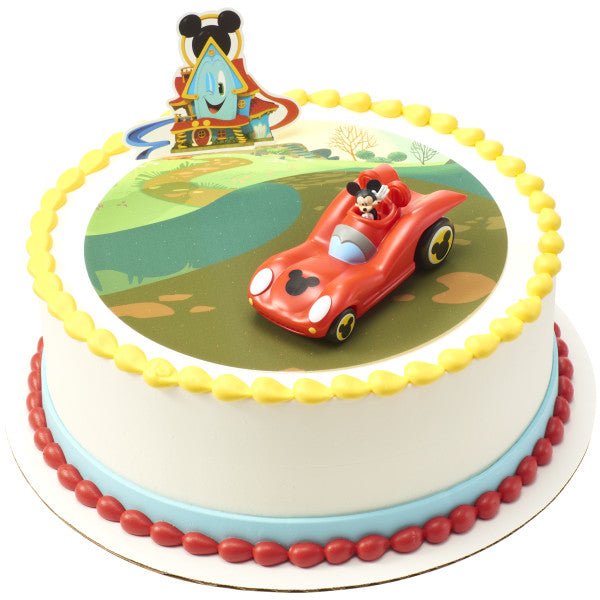 A round cake with a scenic background, decorated with the Mickey Mouse roadster and Funhouse topper.