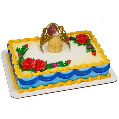 Rectangular cake decorated with Belle and tiara toppers, golden icing trim, blue swags, and red fondant roses.