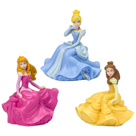 Close-up of three plastic Disney Princess figurines in pink, blue, and yellow dresses, included in the Once Upon A Moment cake kit.