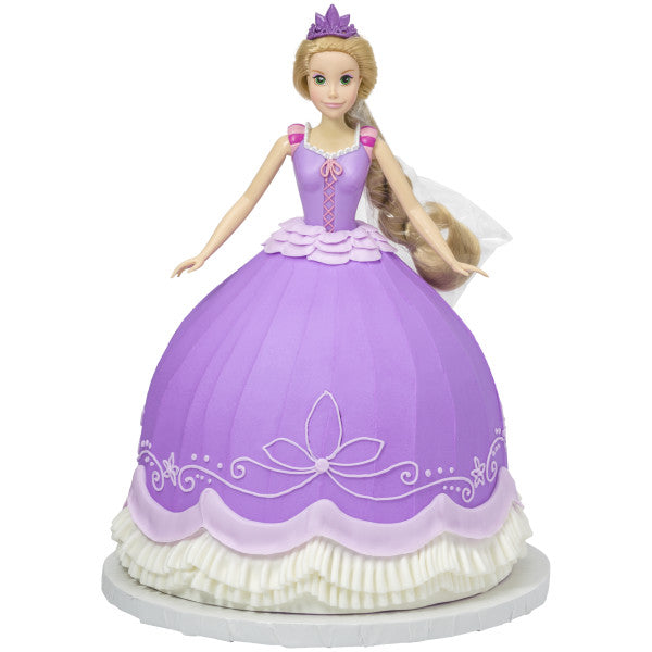 A princess-themed cake decorated with the Rapunzel Signature DecoSet®, featuring the doll as the centerpiece with an elegant, flowing cake dress.