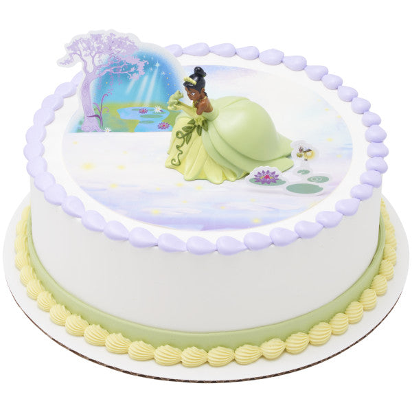 A beautifully decorated round cake with the Tiana figurine and scenic pop-ups for a fairytale-inspired design.