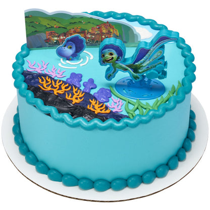 A round cake decorated with ocean elements, bright colors, and the Luca topper set.