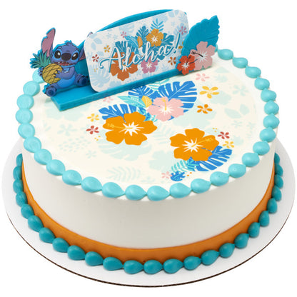 A round cake with blue and orange icing, topped with the Stitch topper and floral accents.