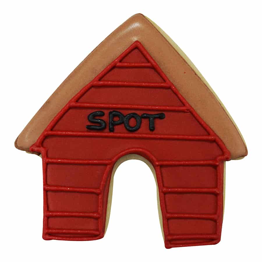 Red and brown decorated dog house-shaped cookie with the name 'Spot' written on the front, made using a dog house cookie cutter, perfect for pet-themed treats.