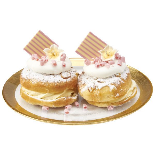 Elegant pastries topped with pink and white chocolate domino squares, whipped cream, and sugar flowers.