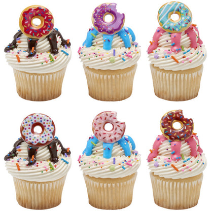 Vanilla cupcakes topped with colorful donut rings, drizzled icing, and rainbow sprinkles, perfect for party treats.