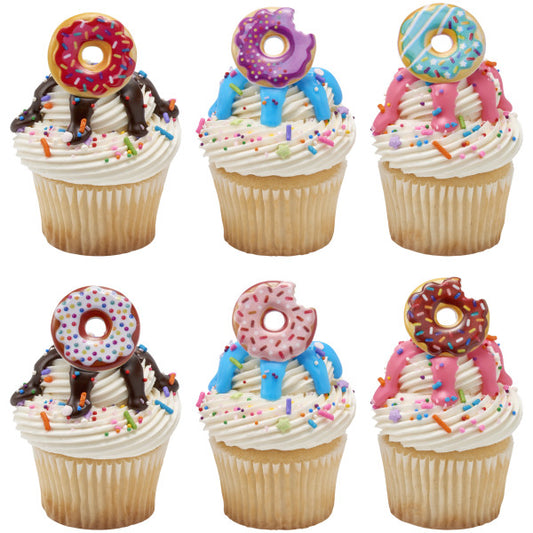 Vanilla cupcakes topped with colorful donut rings, drizzled icing, and rainbow sprinkles, perfect for party treats.