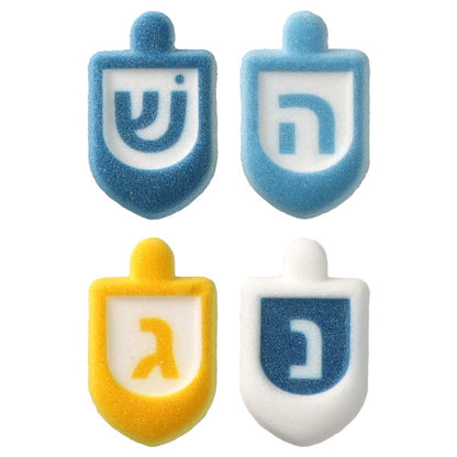 Four pressed sugar dreidel decorations in blue, light blue, yellow-orange, and white with painted Hebrew letters, shown close-up on a white background.