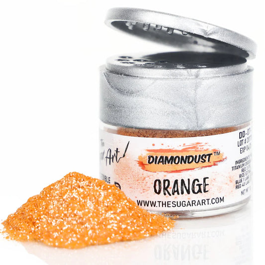 Small jar of edible Orange Diamondust glitter with metallic silver lid, partially open, sitting next to a vibrant pile of fine, shimmering orange glitter dust.
