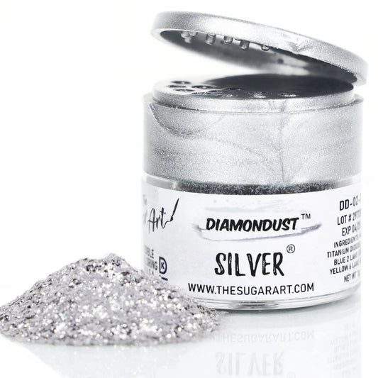 Open jar of DiamondDust Silver edible glitter with a mound of fine silver sparkle in front; silver flip-top lid and product label reading “SILVER” visible. Keywords: silver edible glitter, DiamondDust, cake decorating, 4 grams.