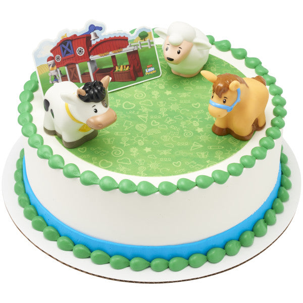 A round cake with a green and blue design, topped with the farm animal finger puppets and backdrop.