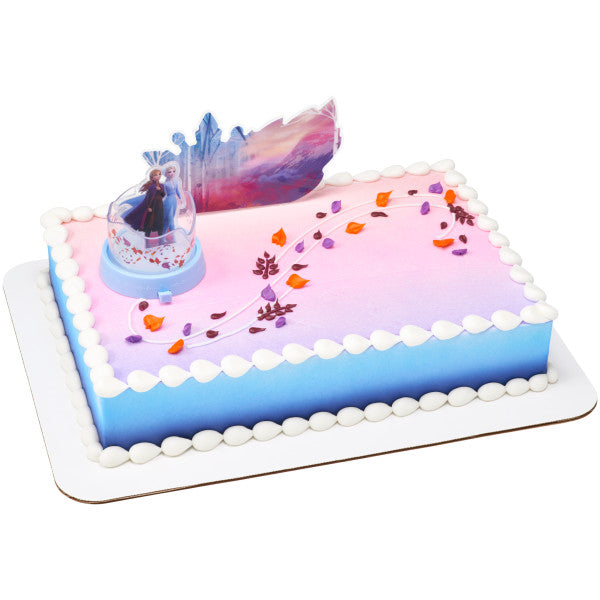 Rectangular cake decorated with the Frozen topper set, an ombré blue-to-pink icing base, and fondant autumn leaves.