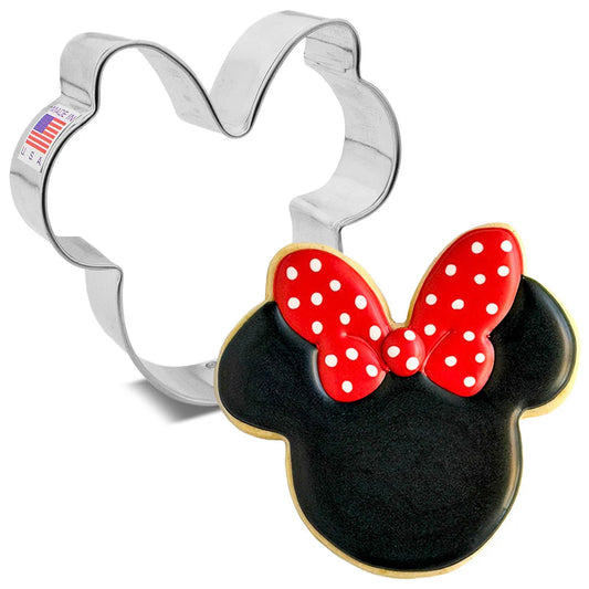 Silver girl mouse cookie cutter with round ears and a bow shape, shown beside a decorated cookie with black icing and a red bow with white polka dots on a white background.