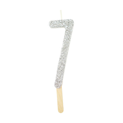 Silver glitter number 7 candle with attached pick, ideal for cakes and celebration decor.