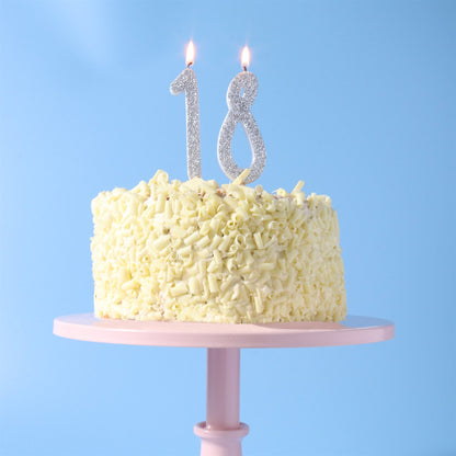 Silver glitter number 1 and number 8 candles in 18th birthday cake.