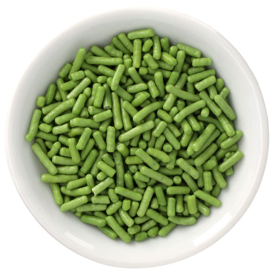 White bowl filled with grassy green Natural Dyed Made Simply™ rod-shaped sprinkles, shown from above against a clean white background.