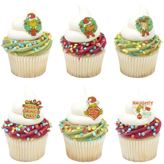 Six vanilla cupcakes with white frosting swirls and colorful sprinkle confetti, each topped with a different Grinch themed pressed sugar decoration including wreath characters, “Merry Grinchmas,” “Grow Your Heart 3 Sizes,” and “Naughty and Nice.”