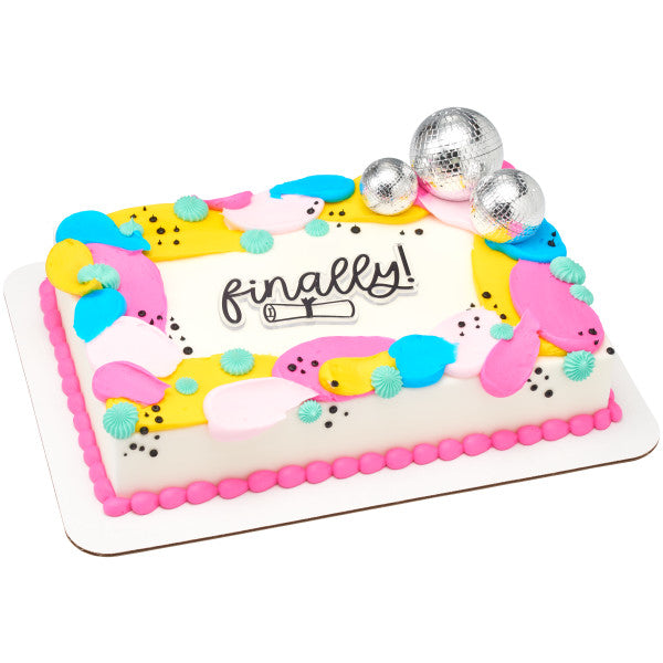 A colorful rectangular cake decorated with pink, blue, and yellow frosting, topped with the Groovy Disco DecoSet disco balls.